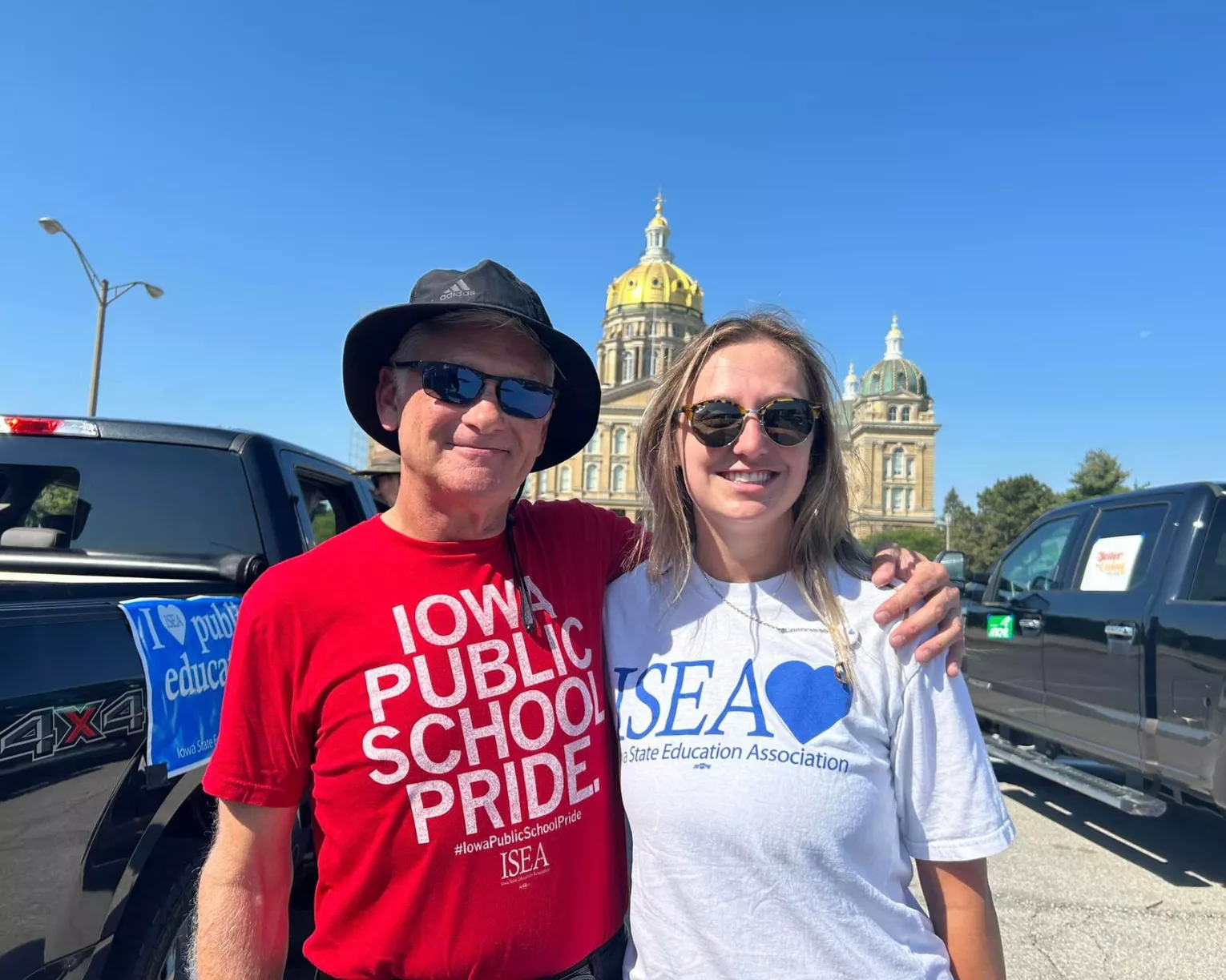 The ISEA president and a member pose for a picture in front of the state capitol.