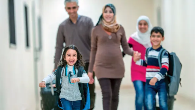 immigrant family of five walk through a hallway