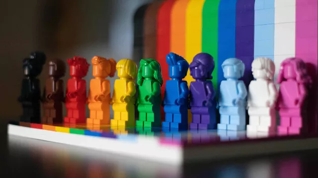 A row of Lego people each representing a color of the rainbow